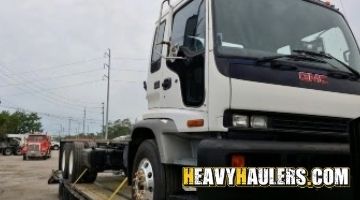 Loading a GMC cabover truck on a trailer.